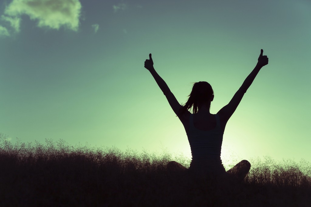 Woman celebrating and showing thumbs up.