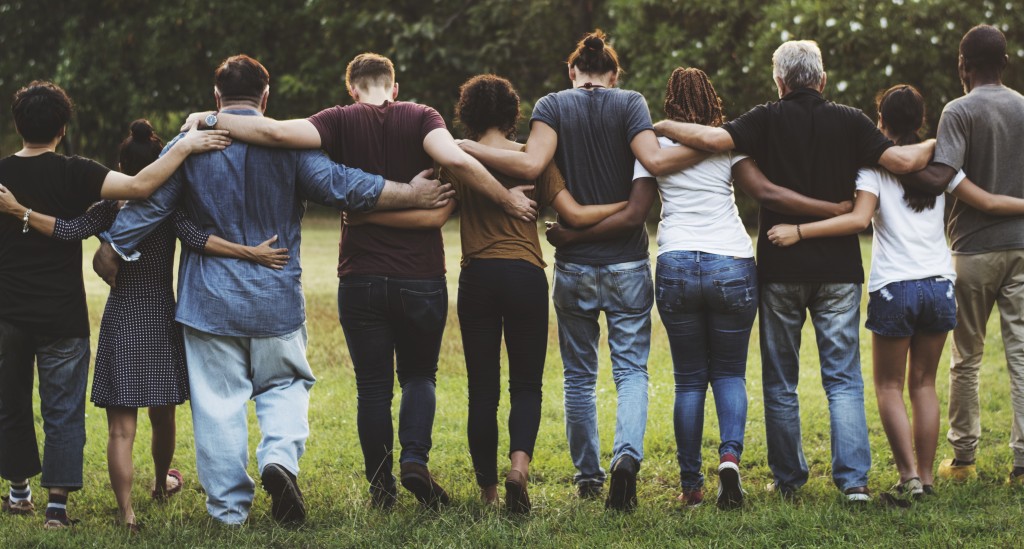 Group of friends huddle in rear view together