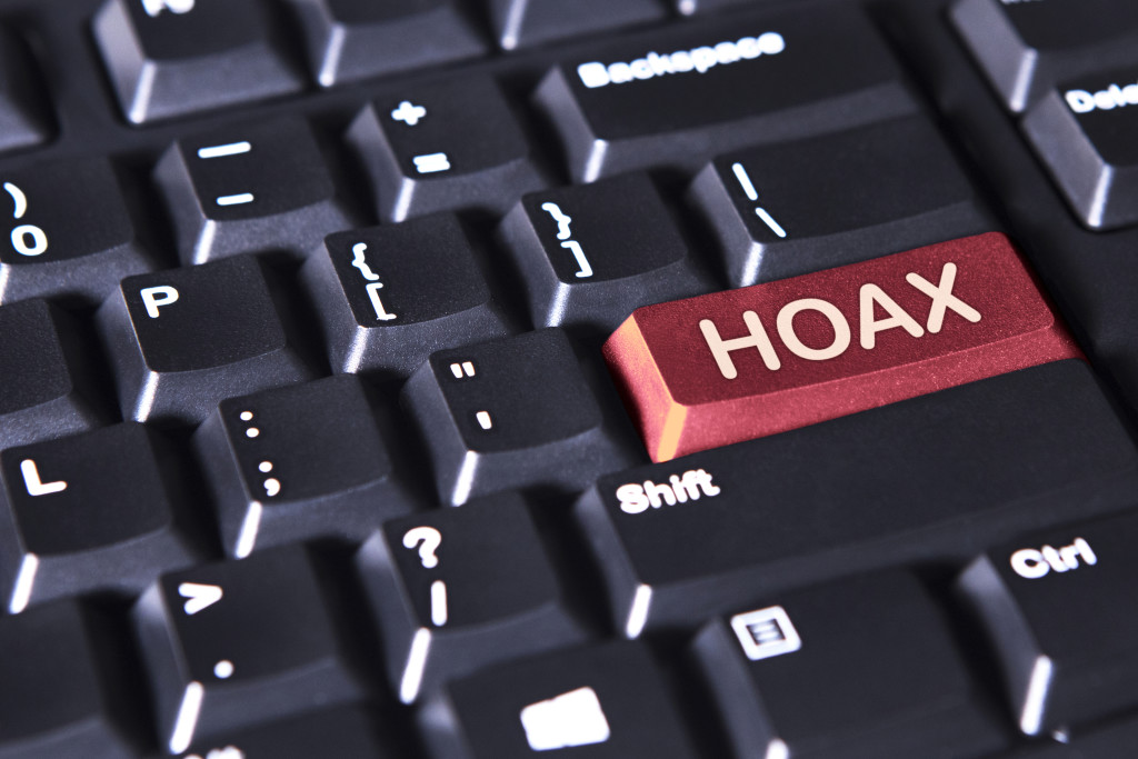 Close up of a computer keyboard with word of hoax on the red button