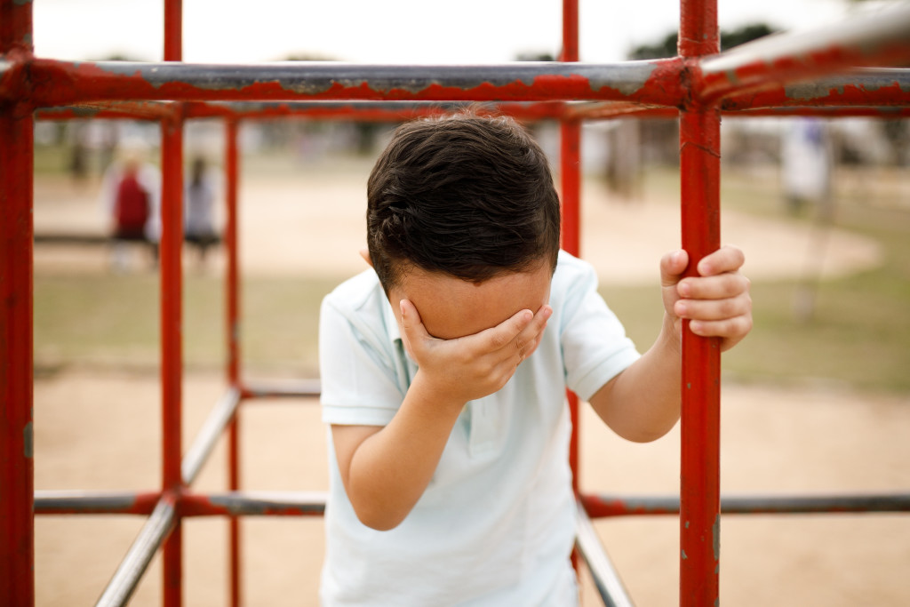 Boy doing a facepalm.